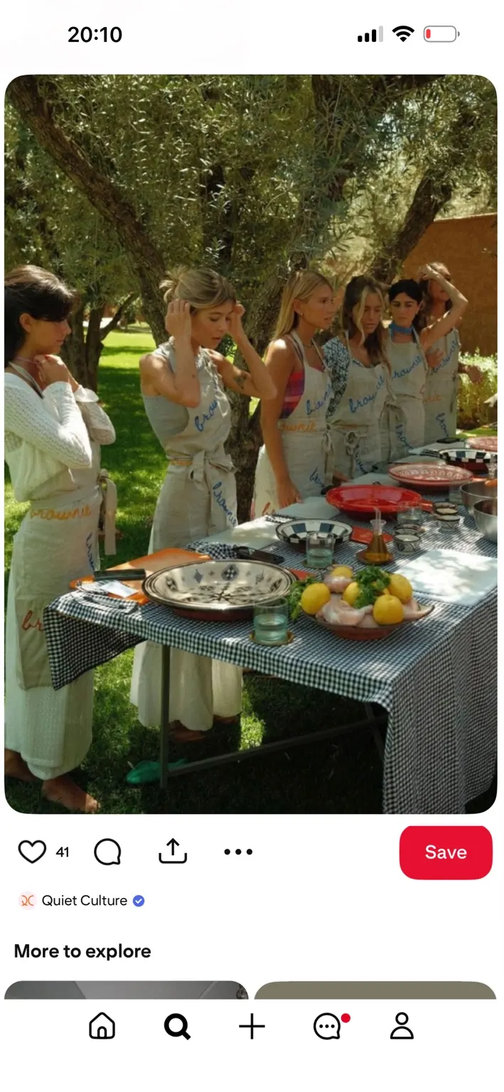 A group wearing aprons gathered for an outdoor cooking session