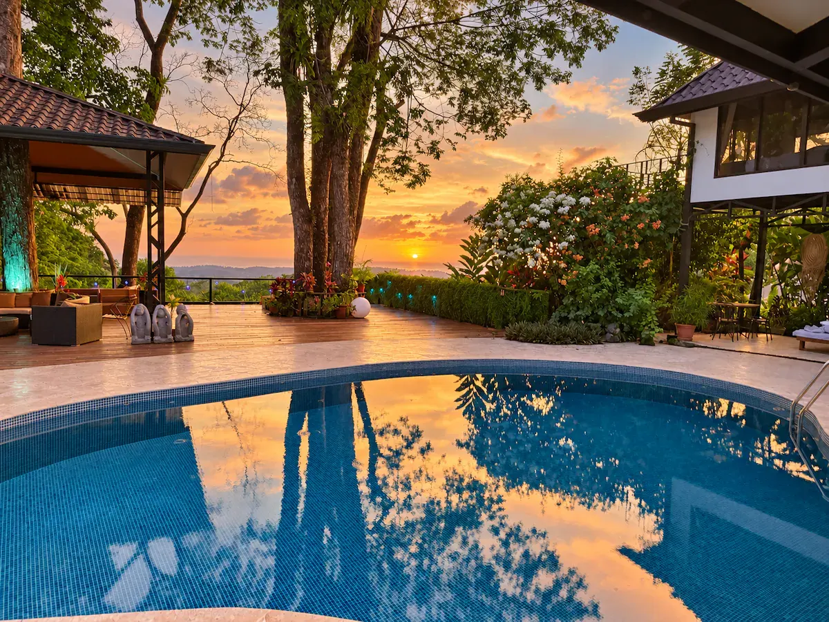 Sunset reflected in the venue pool, with an ocean view beyond